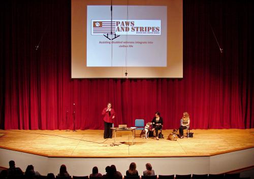 Three women, two dogs on a stage